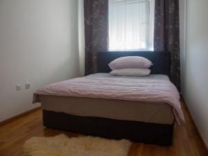 1 cama pequeña en un dormitorio con ventana en Apartman Valerija, en Doboj