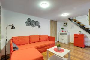 een woonkamer met een oranje bank en een trap bij Mehdi residence 3 in Boedapest