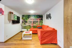 een woonkamer met een oranje bank en een tafel bij Mehdi residence 3 in Boedapest