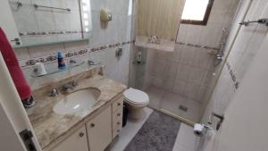 uma casa de banho com um lavatório, um chuveiro e um WC. em Apartamento na Praia do Morro -160 metros da praia -Ar condicionado e internet -Perto de tudo em Guarapari