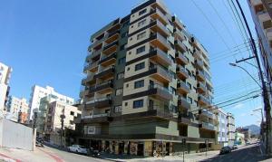 a tall building on the side of a city street at Apartamento na Praia do Morro -160 metros da praia -Ar condicionado e internet -Perto de tudo in Guarapari