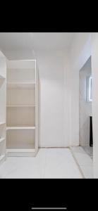 Cette chambre dispose d'étagères blanches et d'un mur blanc. dans l'établissement Kaf lag apartment, à Lekki