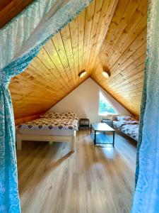 Cette chambre dispose de deux lits et d'un plafond en bois. dans l'établissement Domki Oaza Ciszy, à Polańczyk