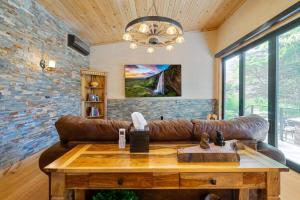 a living room with a leather couch and a table at Encore Cottonwoods Ski Cabin. in Sandy