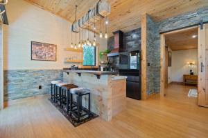 a kitchen with a stone wall and a bar with stools at Encore Cottonwoods Ski Cabin. in Sandy