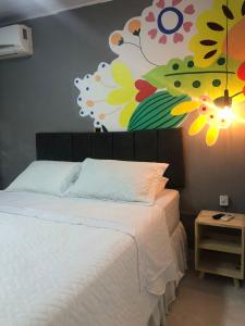 a bedroom with a bed with a painting on the wall at Top Coliving I in Cuiabá