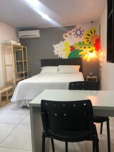 a bedroom with a bed and a table and chairs at Top Coliving I in Cuiabá