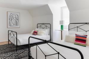 two beds in a room with white walls at Wimberley Inn in Wimberley