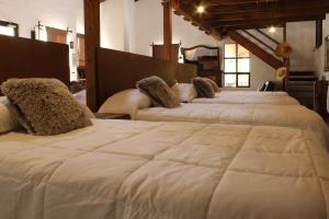 een groep van vier witte bedden in een kamer bij Echological Hotel, Restaurante & Spa in Lagos de Moreno