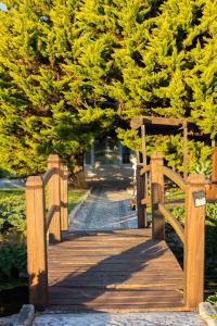 a wooden walkway with a wooden gate in front of trees at KABACEIRA VILLAGE in Atalaia