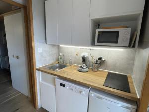 małą kuchnię ze zlewem i kuchenką mikrofalową w obiekcie Studio 4 pers, Quartier des Jeux, Alpe d'Huez - Balcon exposé Sud, proche pistes et commerces - FR-1-405-225 w mieście LʼHuez +4 zdjęcia