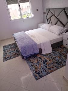 a bedroom with a large bed with a rug at أكادير حي السلام in Agadir