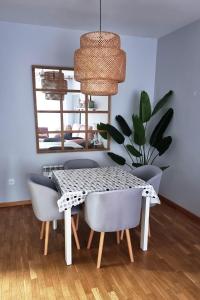 a dining room table with chairs and a potted plant at Piso acogedor con terraza in Ciudad Real