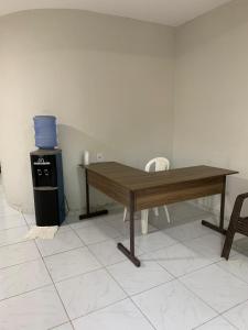 - une table en bois assise dans une pièce avec cuisinière dans l'établissement Pousada Cactus, à Barreirinhas