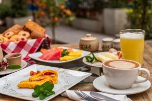 Hotel Xue Sabana في كاجيتسا: طاولة مع أطباق من الطعام وكوب من العصير