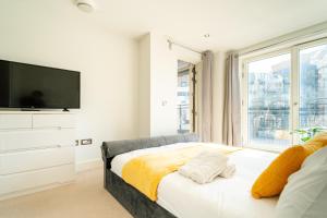 a bedroom with a bed and a large window at Luxury Greenwich 2Bed 2Bath Apt - Sleep 6 Guest- 1 min from station - close to Greenwich Maritime- Playstation provided in London