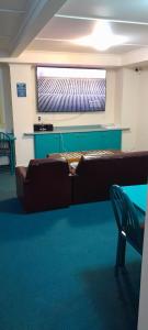 - un salon avec un canapé et une télévision dans l'établissement Pennys Accommodation, à Palmerston North