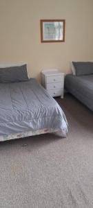 a bedroom with a bed and a dresser and a bed sidx sidx sidx sidx at Pennys Accommodation in Palmerston North
