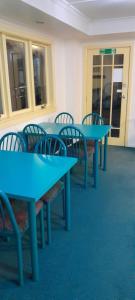 a group of blue tables and chairs in a room at Pennys Accommodation in Palmerston North