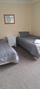 - une chambre avec 2 lits et une table de nuit dans l'établissement Pennys Accommodation, à Palmerston North
