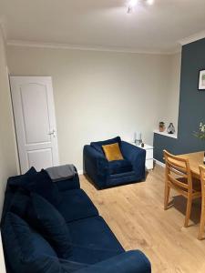 a living room with a blue couch and a table at Family or workers home - transport links & hiking in Porth