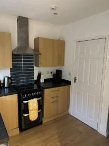 a kitchen with a stove top oven next to a door at Family or workers home - transport links & hiking in Porth