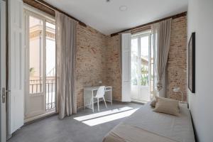 a bedroom with a bed and a brick wall at Residencia Universitaria Trinitarios in Valencia