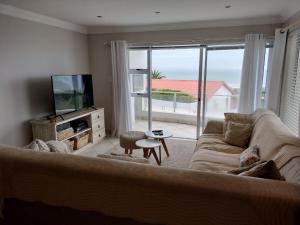 a living room with a couch and a large window at Holiday Home With Sea Views in Jeffreys Bay