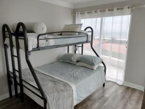 a couple of bunk beds in a room with a window at Holiday Home With Sea Views in Jeffreys Bay