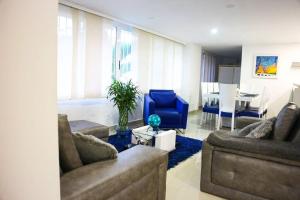 a living room with two couches and a blue chair at edificio astoria in Cali