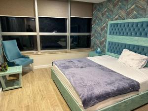 - une chambre avec un lit bleu et une chaise bleue dans l'établissement Centaurus Apartment Islamabad, à Islamabad