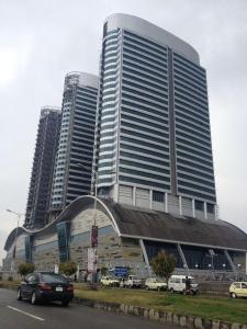 un grand bâtiment avec des voitures garées devant lui dans l'établissement Centaurus Apartment Islamabad, à Islamabad