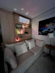 a living room with a white couch and a tv at Apartamento Luxo Recife in Recife