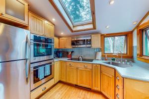 a kitchen with wooden cabinets and stainless steel appliances at Lone Maple in Port Clyde