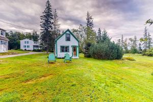 a small house with two chairs in a yard at Lone Maple in Port Clyde