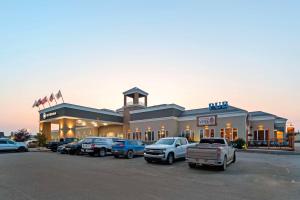 a building with cars parked in a parking lot at Best Western High Road Inn in Edson