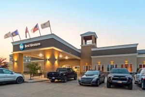 un concesionario con coches estacionados en un estacionamiento en Best Western High Road Inn, en Edson