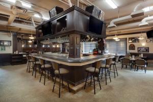 Un bar en un restaurante con taburetes. en Best Western High Road Inn, en Edson