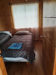 Cabaña en Chacao Viejo, Chiloé - Tranquilidad y Frente al mar في أنكود: غرفة نوم صغيرة بها سرير ونافذة