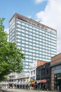a tall building with many windows on a city street at Hampton by Hilton Birmingham Broad Street in Birmingham