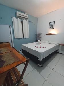 a room with a bed and a table and a table and chairs at Pousada Apart Amor de Jeri in Jericoacoara