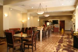 un restaurant avec des chaises et des tables ainsi qu'un bar dans l'établissement Hampton Inn Williamsburg, à Williamsburg