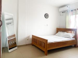 um pequeno quarto com uma cama e um espelho em Residence Atlantic - Premium Apartment - WiFi, Gardien, Parking, Climaté em Douala