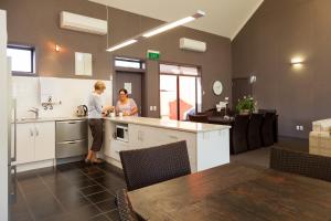a man and a woman standing in a kitchen at Hawkdun Lodge Motel in Ranfurly