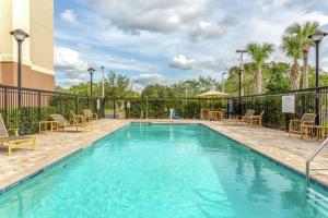 a swimming pool at a hotel with chairs and tables at Hampton Inn Okeechobee - Lake Okeechobee in Okeechobee