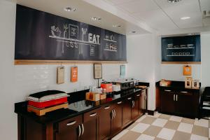 a restaurant with a counter with boxes on it at Hampton Inn & Suites Mishawaka/South Bend at Heritage Square in South Bend