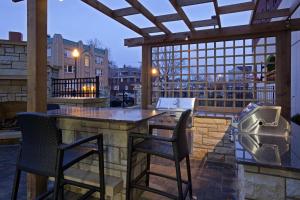 a patio with two chairs and a bar with a grill at Homewood Suites by Hilton Rochester Mayo Clinic-St. Marys Campus in Rochester