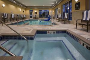 a pool in a hotel with chairs and tables at Homewood Suites by Hilton Rochester Mayo Clinic-St. Marys Campus in Rochester