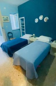 a bedroom with two beds and a blue wall at Domi B & B in Macerata