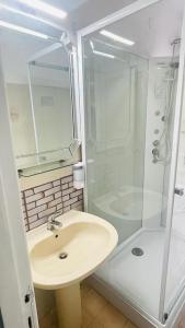 y baño blanco con lavabo y ducha. en Domi B & B en Macerata